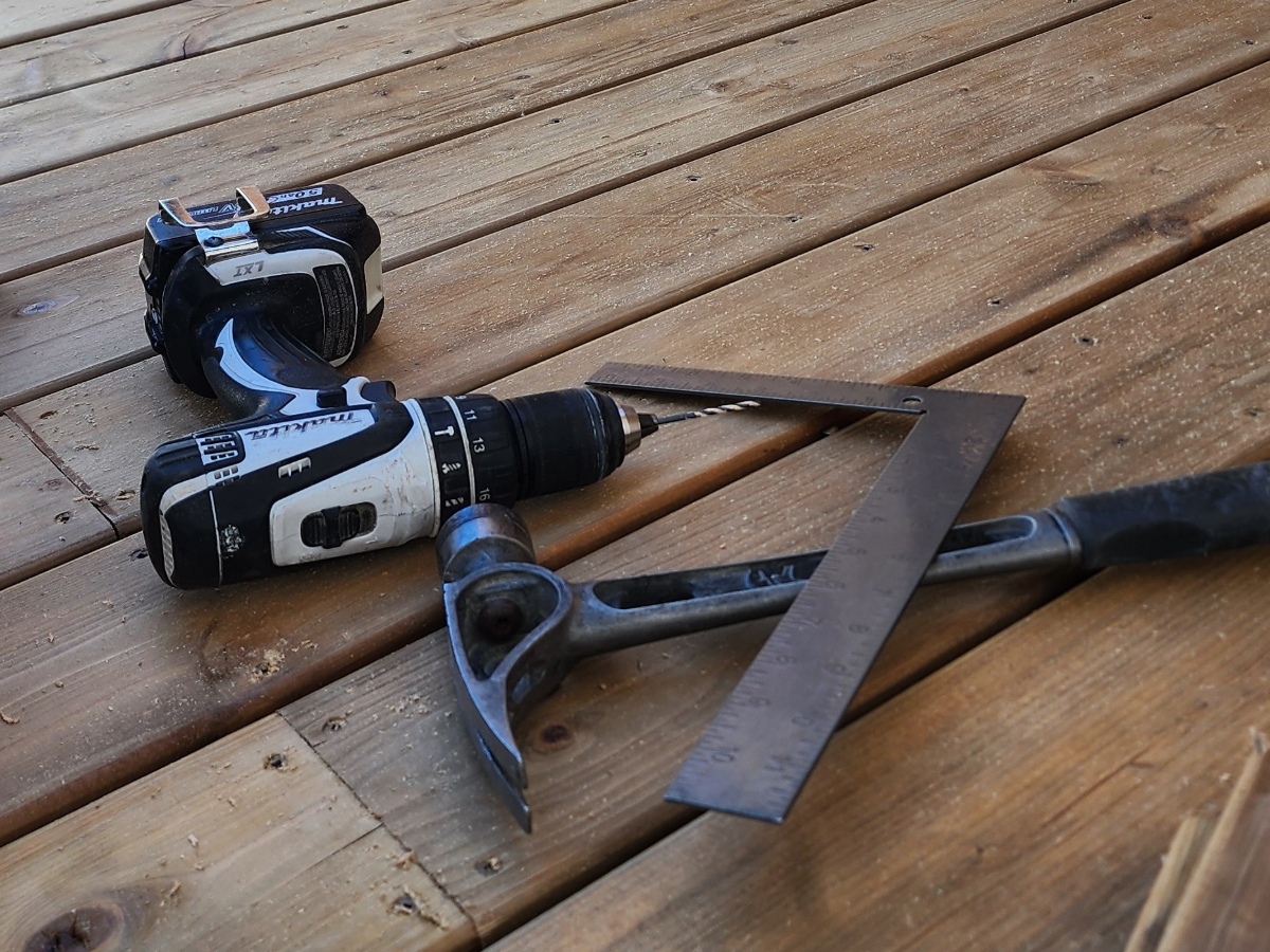 Drill, hammer and framing square on a newly built deck during custom carpentry work in Vancouver, BC.