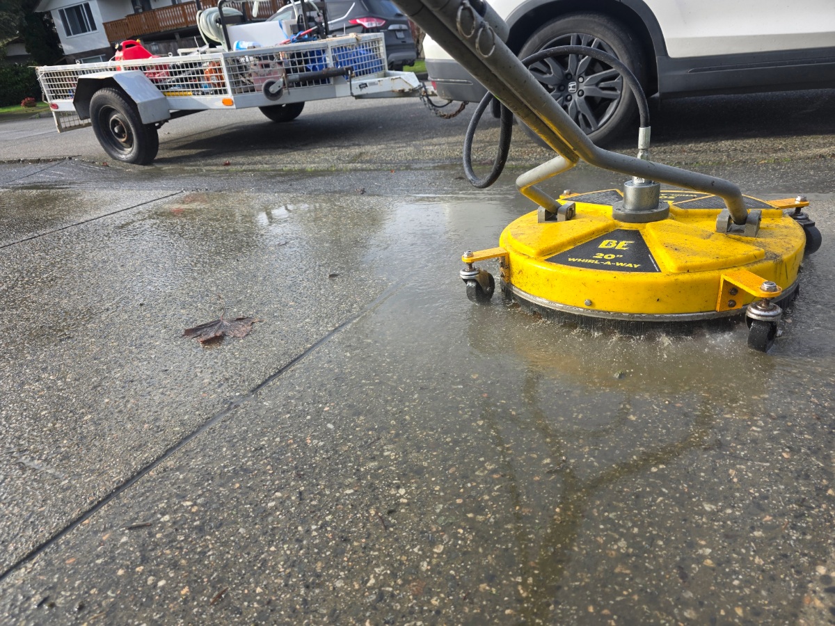 Pressure washing a concrete driveway with a surface cleaner in Richmond, BC.